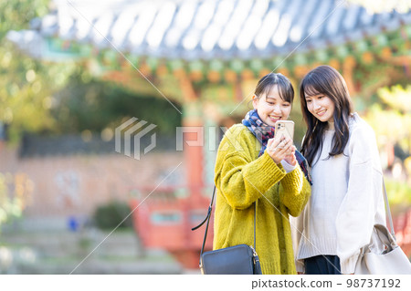 Young woman taking a commemorative photo with a smartphone 98737192