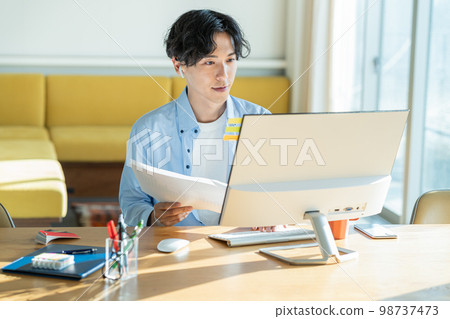 Young man working remotely 98737473