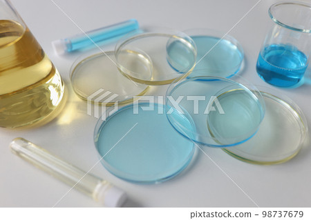 Laboratory glassware with colored liquids on lab table close up. Laboratory glassware with colored liquids on lab table close up. 98737679