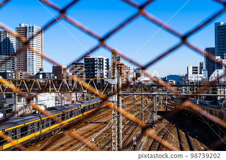 東京郊區 透過三鷹立交橋的鐵絲網和三鷹站周邊地區看到的火車 2023.01 b-2 高飽和度對比度 98739202