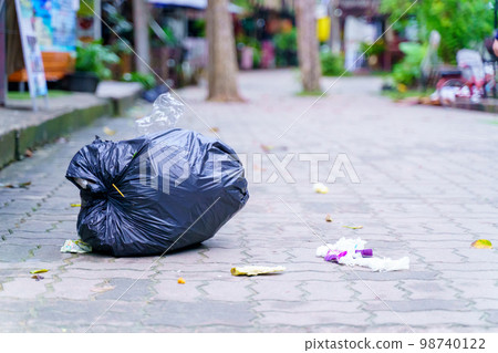 Spilled garbage on streets of big city with garbage sitting on the ground Spilled garbage on streets of big city with garbage sitting on the ground 98740122