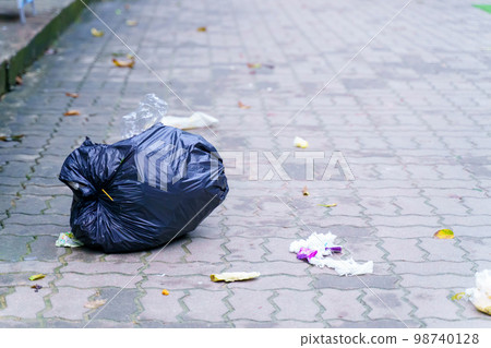 Spilled garbage on streets of big city with garbage sitting on the ground Spilled garbage on streets of big city with garbage sitting on the ground 98740128