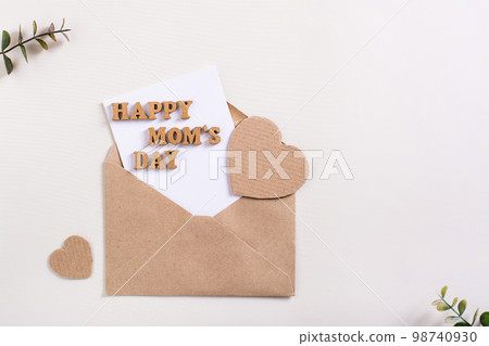 Happy mother's day. Envelope with a sheet, letters and hearts on a light background. 98740930