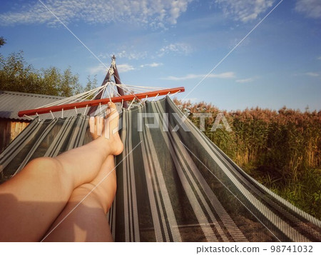 woman resting on hammock during summer vacations woman resting on hammock during summer vacations 98741032