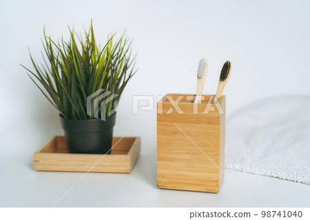 two toothbrushes in bamboo folder. white towel and artificial flower on white background two toothbrushes in bamboo folder. white towel and artificial flower on white background 98741040