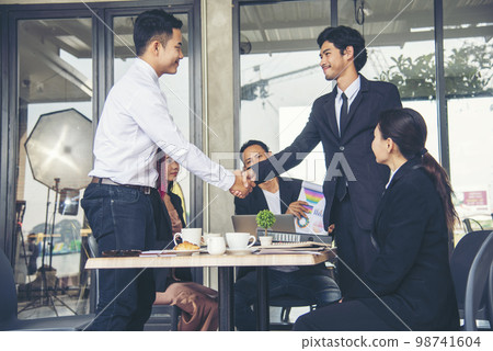 Team Business Partners shaking hands together to Greeting Start up small business in meeting room. Shakehand teamwork partners at modern office handshake together. Business mergers and acquisitions 98741604