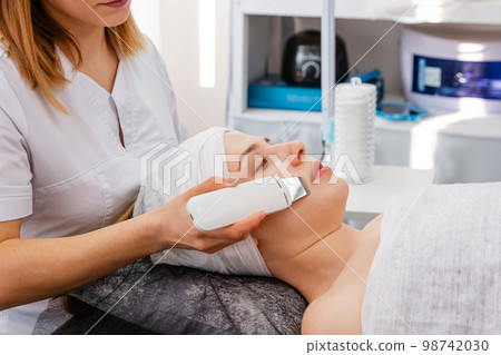 Ultrasound skin cleaning at beauty salon. 98742030