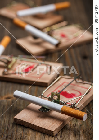 Cigarette in mousetrap 98742797