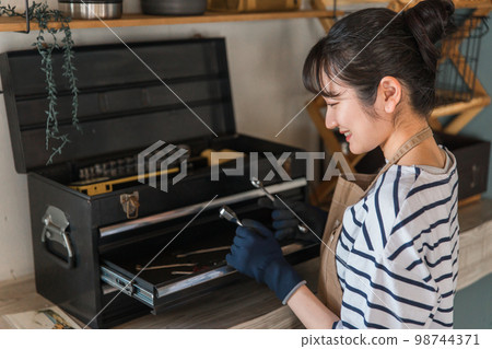 A woman who uses tools in her garage (DIY, craft, DIY) A woman who uses tools in her garage (DIY, craft, DIY) 98744371