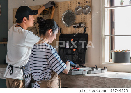 男人和女人在房子的車庫裡使用工具(DIY、工藝、DIY) 男人和女人在房子的車庫裡使用工具(DIY、工藝、DIY) 98744373
