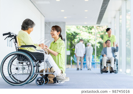 Senior woman and young care worker in nursing home 98745016
