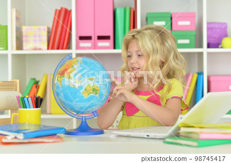 girl studying with a globe at the table 98745417