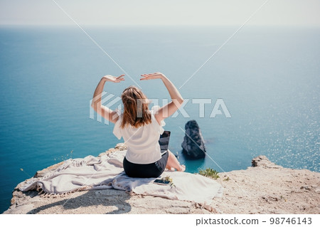 Woman sea laptop. Successful business woman working on laptop by the sea. Pretty lady typing on computer at summer day outdoors. Freelance, digital nomad, travel and holidays concept. 98746143