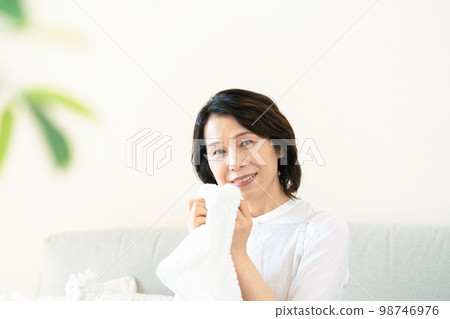 一位女士確認洗過的毛巾的氣味 98746976