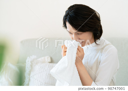 一位女士確認洗過的毛巾的氣味 98747001