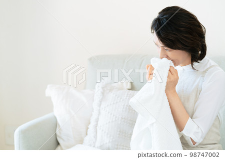 一位女士確認洗過的毛巾的氣味 98747002