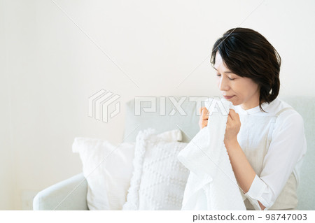 一位女士確認洗過的毛巾的氣味 98747003