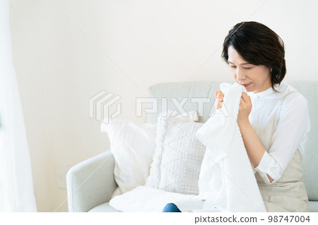 一位女士確認洗過的毛巾的氣味 98747004