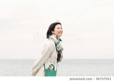 A woman walking along the beach A woman walking along the beach 98747091