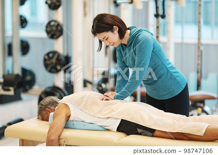 Trainer giving a massage at the gym 98747106