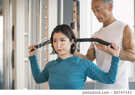 Young woman doing muscle training at personal training gym Young woman doing muscle training at personal training gym 98747141