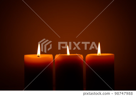 three burning candles in the dark. Memories and blessings 98747988