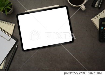 Flat lay digital tablet with white blank screen, cup of coffee and notepad on black slate texture background 98748061