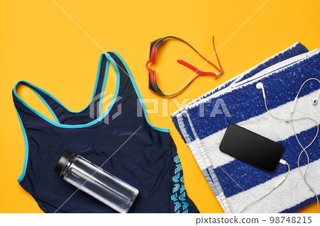 Flat lay summer pool accessories on a yellow background. Colorful beach wear. 98748215
