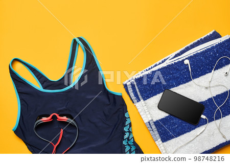 Flat lay summer pool accessories on a yellow background. Colorful beach wear. 98748216