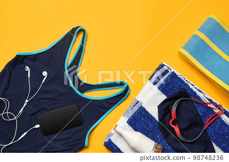 Flat lay summer pool accessories on a yellow background. Colorful beach wear. 98748236