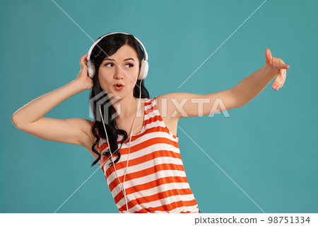 Studio photo of a gorgeous girl teenager posing over a blue background. 98751334