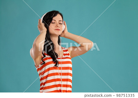 Studio photo of a gorgeous girl teenager posing over a blue background. 98751335