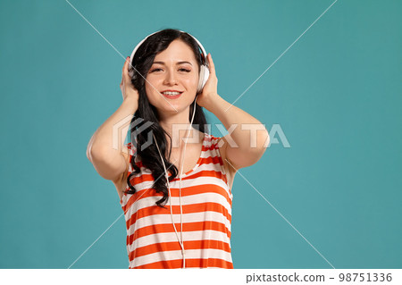 Studio photo of a gorgeous girl teenager posing over a blue background. 98751336
