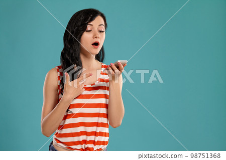 Studio photo of a gorgeous girl teenager posing over a blue background. 98751368