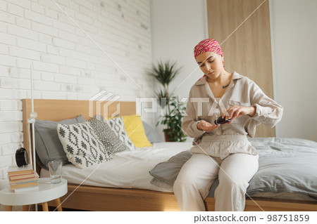 Young woman with cancer taking pills, cancer awareness concept. 98751859