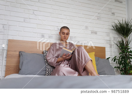 Young woman with cancer reading book, cancer awareness concept. 98751889