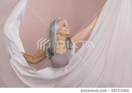 Portrait of smiling senior woman in studio. 98752068