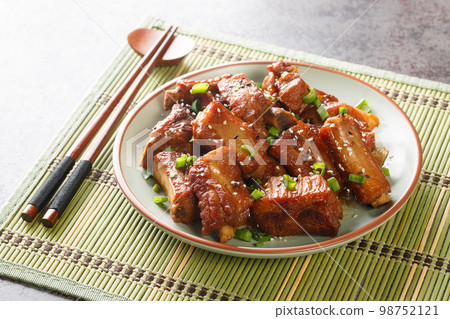 Barbecue sweet and sour spire ribs with green onion and sesame close-up in a plate. Horizontal 98752121