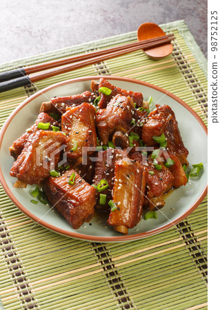 Fried pork short ribs in sweet and sour sauce in Asian style close-up in a plate. vertical 98752125