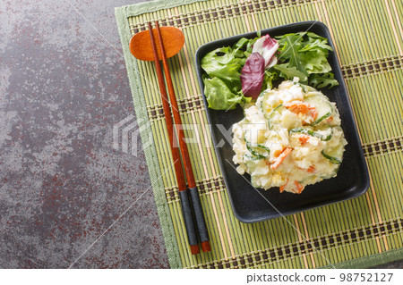 Japanese cold potato salad with carrots, cucumbers and mayonnaise close-up in a plate. horizontal top view Japanese cold potato salad with carrots, cucumbers and mayonnaise close-up in a plate. horizontal top view 98752127