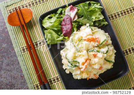 Japanese potato salad is like semi-mashed potatoes mixed with vegetables, egg and mayonnaise close-up in a plate. Horizontal top view 98752129