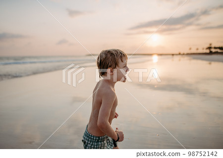 Little boy in swimsuit running out of sea, enjoying holiday. Little boy in swimsuit running out of sea, enjoying holiday. 98752142