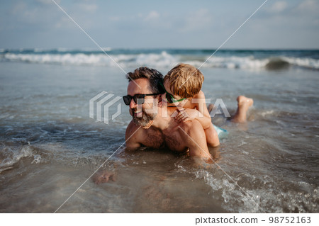 Father with his little son in ocean, enjoying summer vacation. Father with his little son in ocean, enjoying summer vacation. 98752163