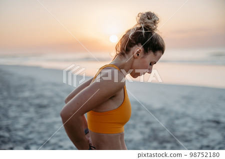 Close-up of young sportive woman at beach. 98752180