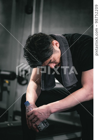 Man taking a training break at the gym Man taking a training break at the gym 98752209