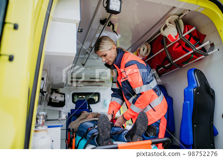 Rescuer taking care of patient, preparing her for transport. Rescuer taking care of patient, preparing her for transport. 98752276