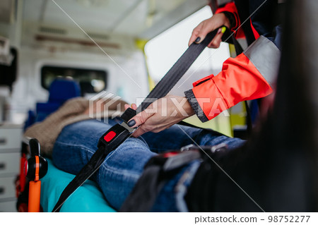 Rescuer taking care of patient, preparing her for transport. Rescuer taking care of patient, preparing her for transport. 98752277