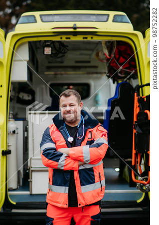 Portrait of doctor standing in front of ambulance car. 98752282