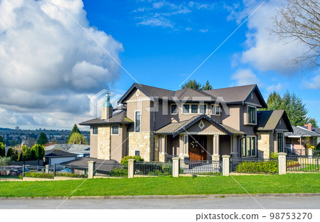 Big residential house on bluesky background with metal fence in front 98753270