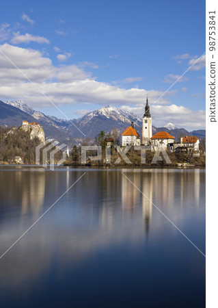 Bled lake with Bled catle, church and winter Julian Alps at background 98753841